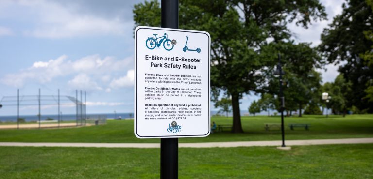 Sign that lists rules for E-bikes and E-scooters within Lakewood city parks.