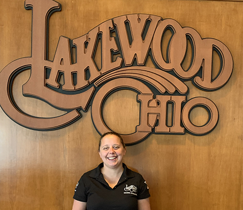 Jaclynn Varady in front of a wood Lakewood Ohio logo.