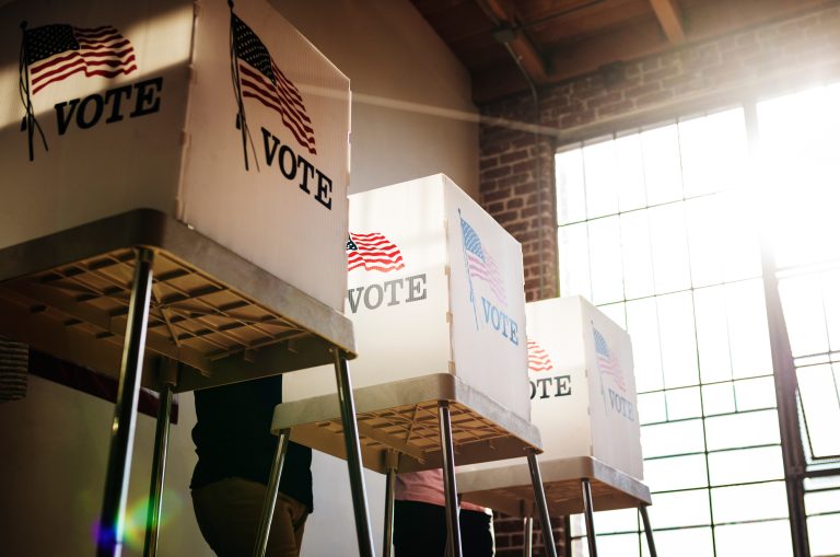 Voting booths in front of a window.